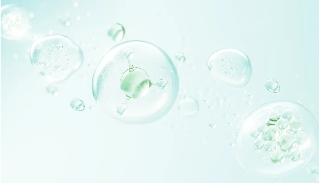 Translucent bubbles of varying sizes float against a soft, pale teal background. The bubbles are clear with some containing smaller spheres within. Light reflections are visible on the bubbles, giving a fresh and airy feel to the image.