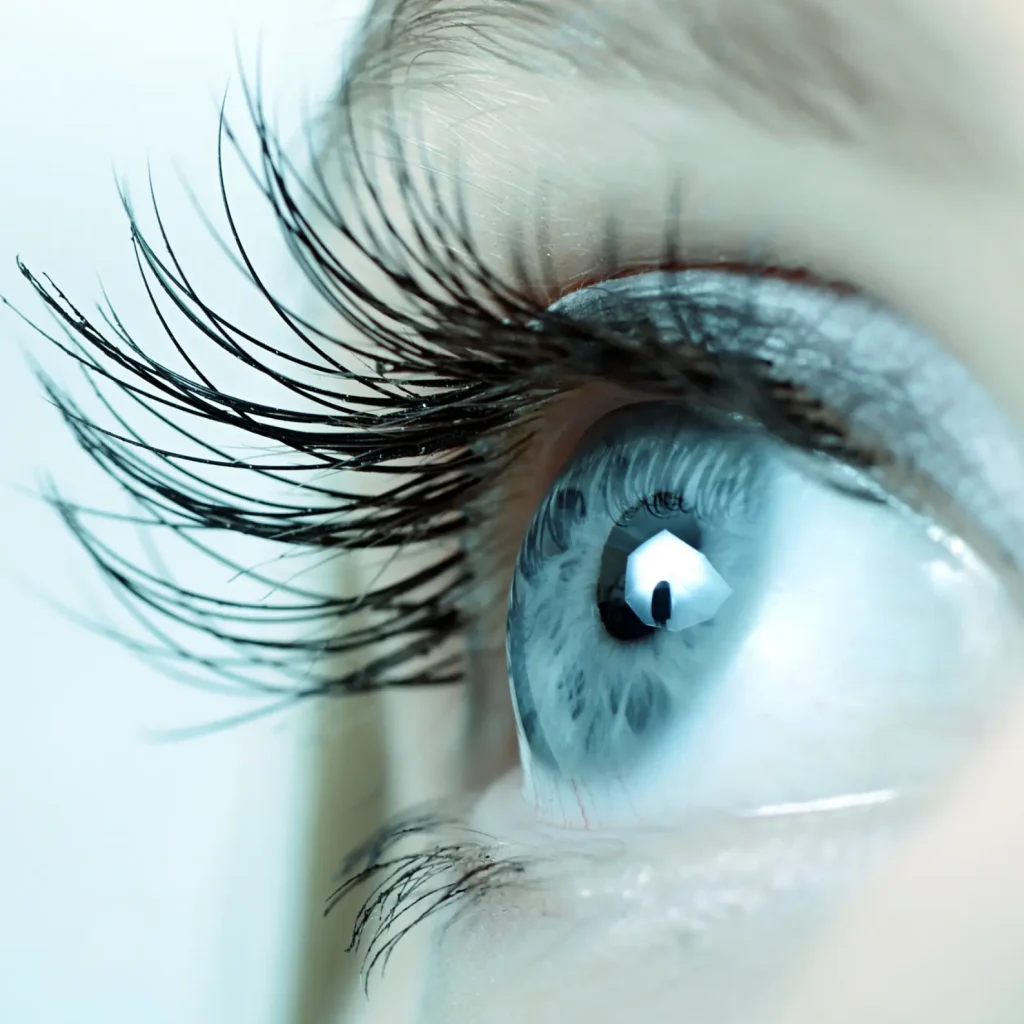 A close-up of a blue eye looking upwards, with long, well-defined eyelashes resembling the precision of a development platform. The eyelid sports light blue eyeshadow, enhancing the cool-toned appearance, while lighting highlights the eye\'s intricate details and color.