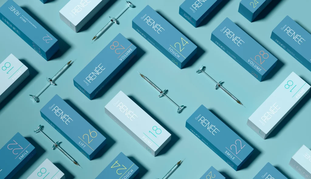 Multiple teal and blue rectangular skincare product boxes are arranged diagonally on a light blue background. Metal applicators are interspersed among the boxes. Each box displays the brand "Dr. Renée" and different product features.