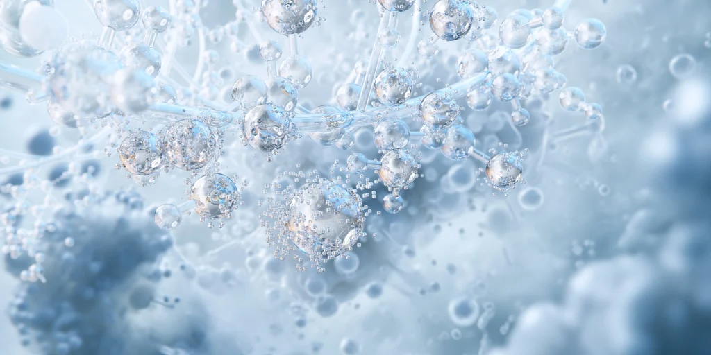 Abstract image of transparent and reflective bubbles and spheres, interconnected by thin strands, floating in a soft, cloudy, light blue and white background, evoking a microscopic or molecular scene.